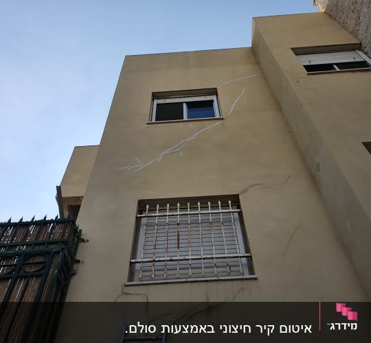 קירות עם סדקים ותיקוני איטום נראים בבניין